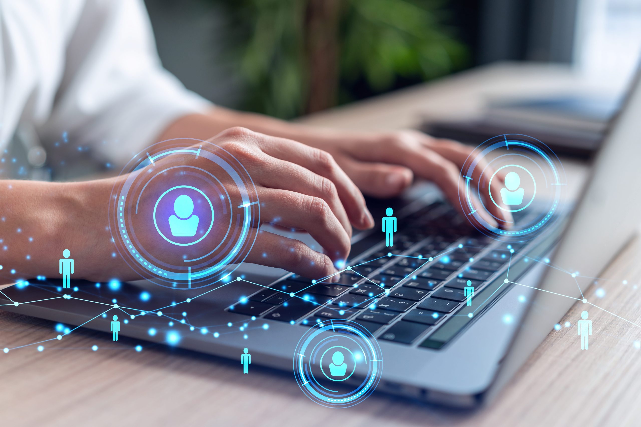 A person types on a laptop keyboard, with digital network icons of people and connection lines overlaid, symbolizing digital communication or online networking.